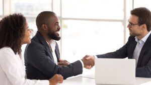 Three people in a meeting shaking hands