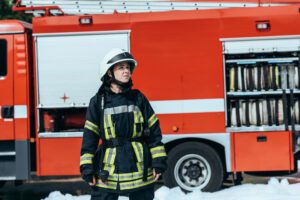 Image of a female firefighter standing in front of a fire truck