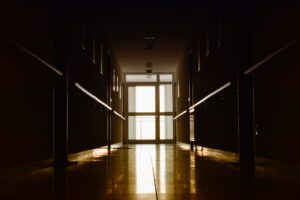 Image of a dark hallway with a brightly lit door at the end