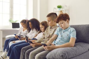 Image of children looking at their cell phones