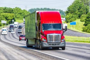 Image of a red semi on the highway with other vehicles