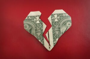 Image of dollar bill folded in the shape of a broken heart