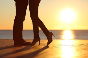 Image of silhouette of couple's legs at sunset