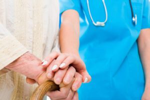 Image of healthcare worker comforting an elderly person holding a cane