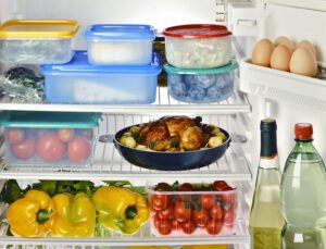 Image of the inside of a refrigerator with food in plastic storage containers