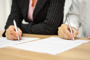 Image of two people signing paperwork