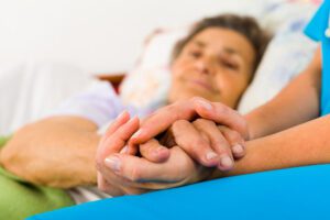 Image of medical professional holding an elderly person's hand