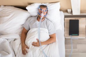 Image of a man sleeping with a CPAP machine