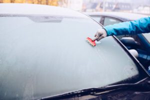 Image of person scraping ice off of a vehicle window