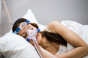 Image of woman wearing a CPAP mask while sleeping