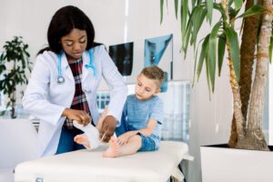 Image of doctor wrapping a young boy's ankle