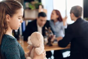 Image of arguing couple with a child holding a stuffed bear