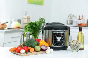 Image of pressure cooker on counter with rice and vegetables