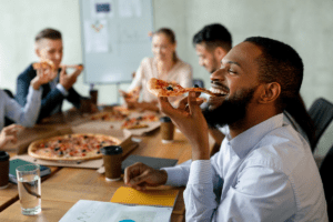 Image of happy people eating pizza at a table