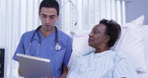 Image of doctor standing bedside with senior patient