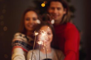 Image of happy couple with daughter holding sparklers