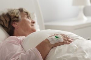 Image of elderly woman in a hospital bed with an IV