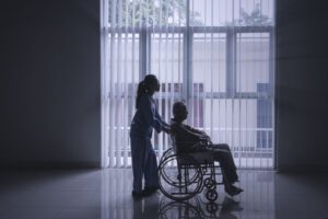 Image depicting healthcare worker pushing elderly man in a wheelchair