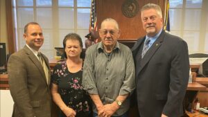 Image of three men and one woman following lawsuit being awarded