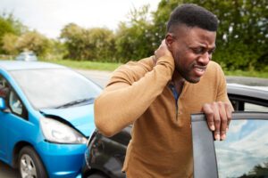 Image of man holding his neck in pain after a car accident