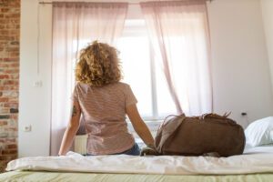 Image of woman on bed with bag packed