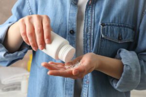 Person pouring talcum powder in their hand