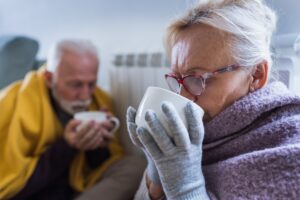 Image of two older people driving warm beverages from mugs