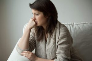 Woman looking thoughtful with her chin on her hand