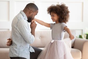 Image of dad kissing the hand of his daughter wearing a tutu