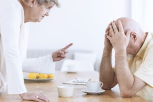 Image of elderly woman waving her finger at elderly man who has his head in his hands