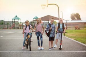 Image of kids on scooters and bikes at a playground