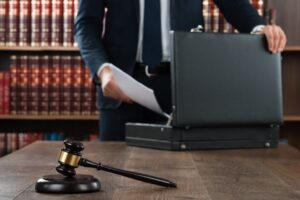 Image of attorney behind a gavel putting paperwork in a briefcase