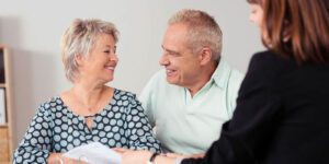 Image of happy senior couple with woman looking at paperwork