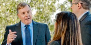 Image of Craig Carlson speaking to two other people in suits