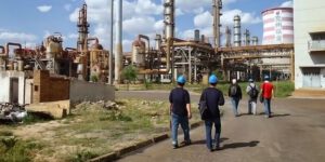 Image of workers in safety helmets walking into a chemical plant