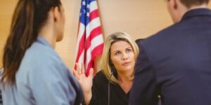 Graphic of a man and woman speaking to a judge in front of an american flag