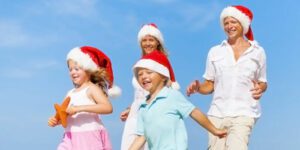 Image of family with two small children wearing santa hats