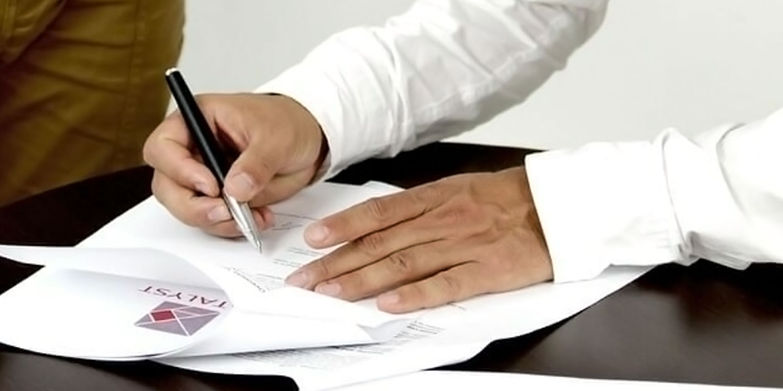 Image of a person signing paperwork