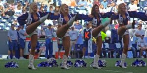 Image of Dallas Cowboys cheerleaders doing high kicks on the field