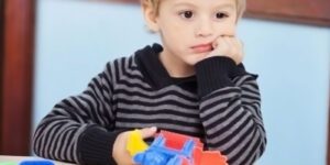 Image of a child looking sad with a toy in their hand