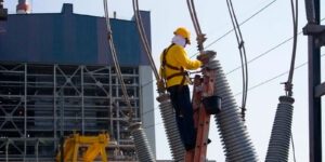 Image of worker in safety gear working on power lines