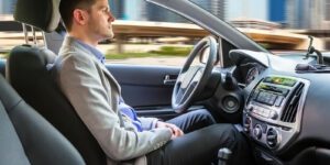 Image of man sitting in a self driving vehicle