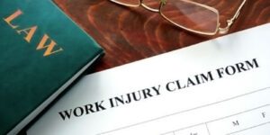 Image of work injury claim form, glasses, and law book