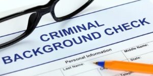 Image of criminal background check form, pen, and eyeglasses