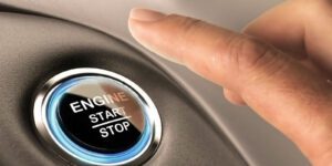 Image of hand pushing engine start stop button