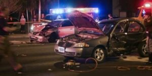 Image of a multi-car accident at night with onlookers and emergency personel