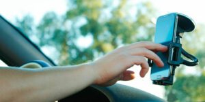 Image of person using their smart phone that is mounted on their window shield