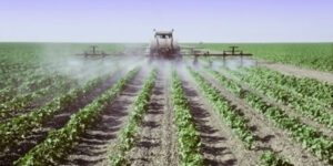 Image of tractor treating crops for pests