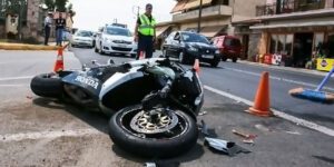 Image of motorcycle accident on a busy city street with public safety workers standing by