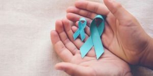 Image of hands holding teal ovarian cancer awareness ribbons